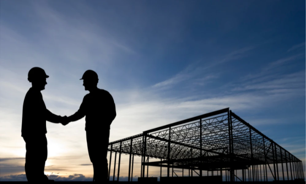 Builders shaking hands on a construction site